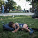 An Afghan child naps in ‘Afghan Park’ as asylum-seekers around him seek out smugglers.
